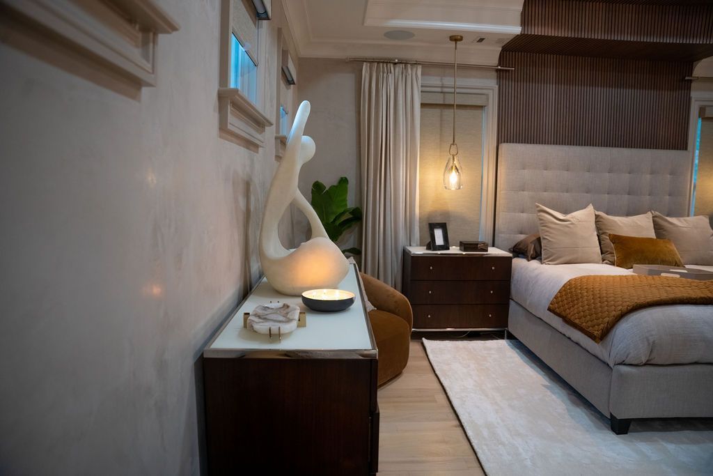 Cozy bedroom with a bed, bedside lamps, wood furniture, and a decorative white bunny statue