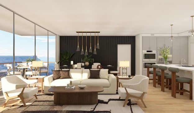 Bright modern living room with ocean view, beige sofas, wood accents, and open kitchen-dining area