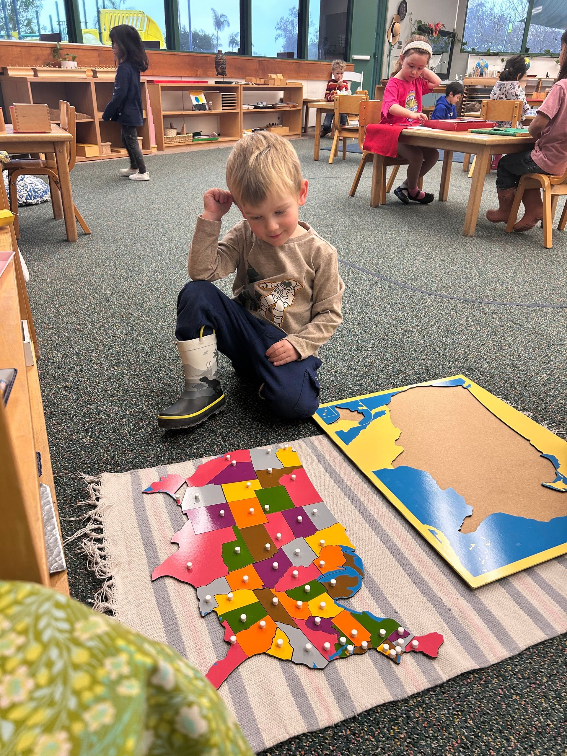 Montessori child working with a map puzzle.