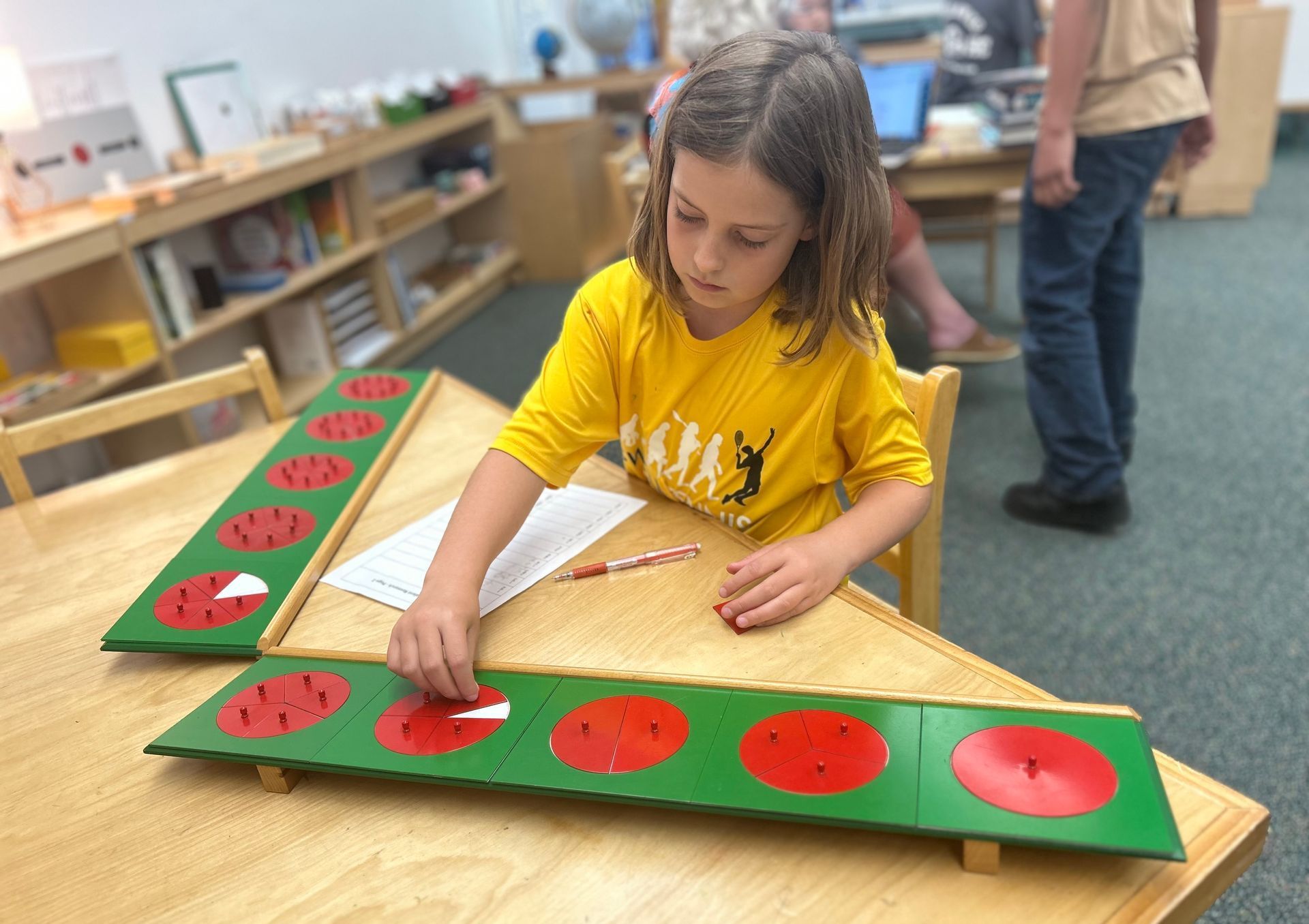 Child working with the Montessori fractions puzzles board