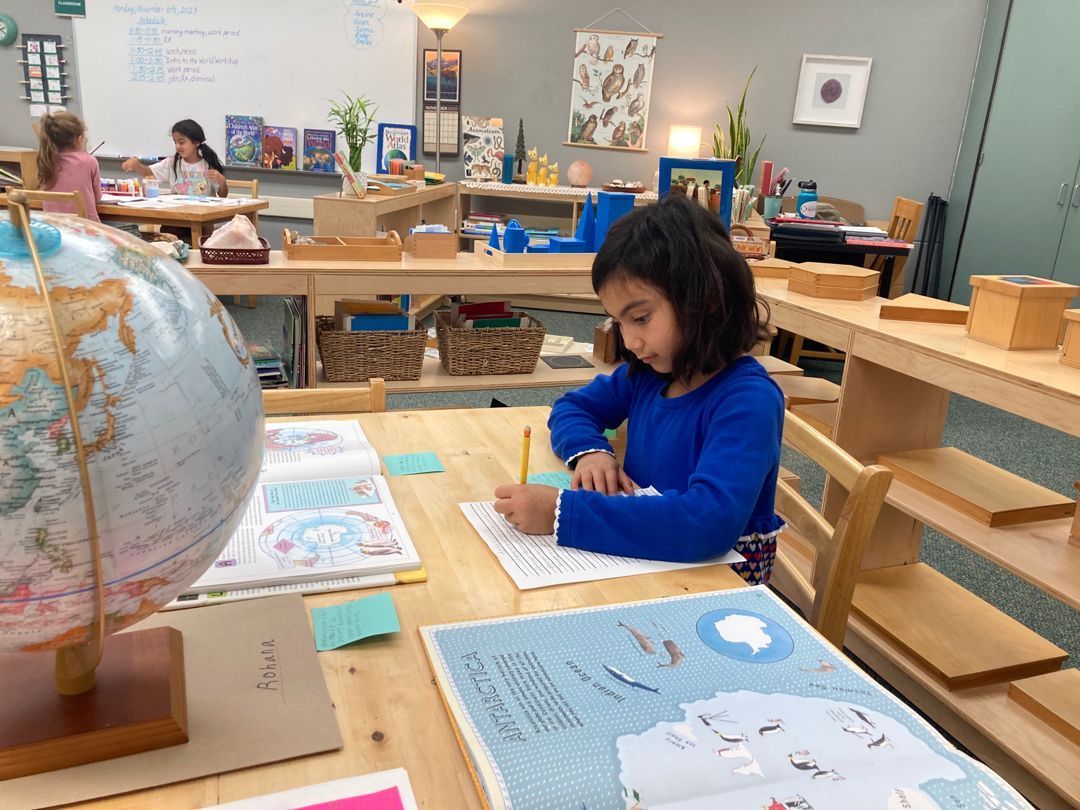 montessori child writing on a paper