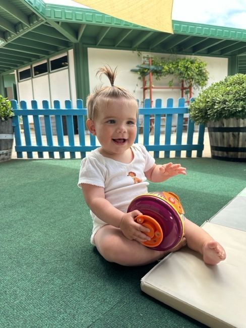 montessori infant sitting outdoors