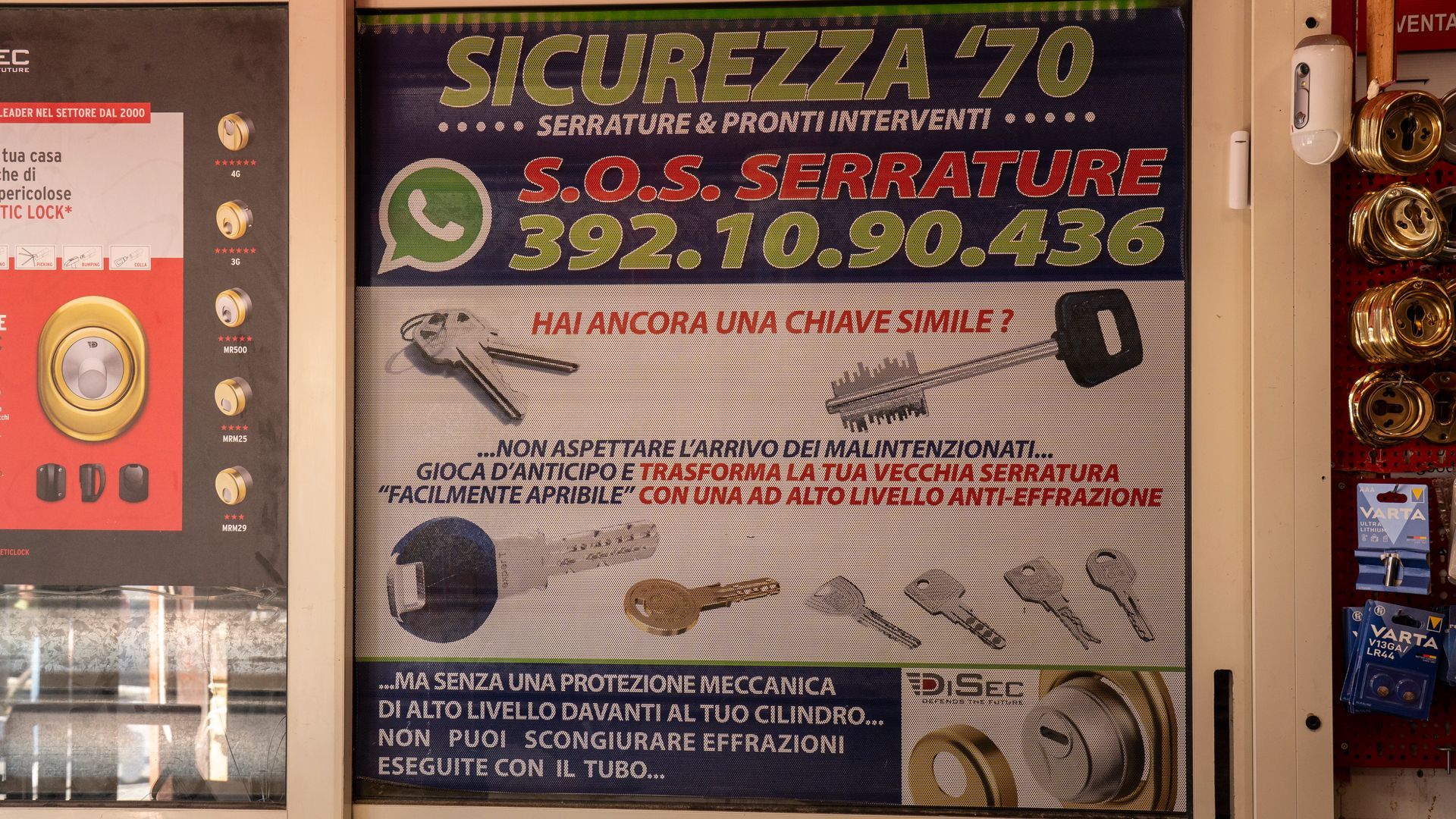 Insegna di un negozio di serrature italiano con la scritta in giallo a caratteri cubitali “SICUREZZA 70”