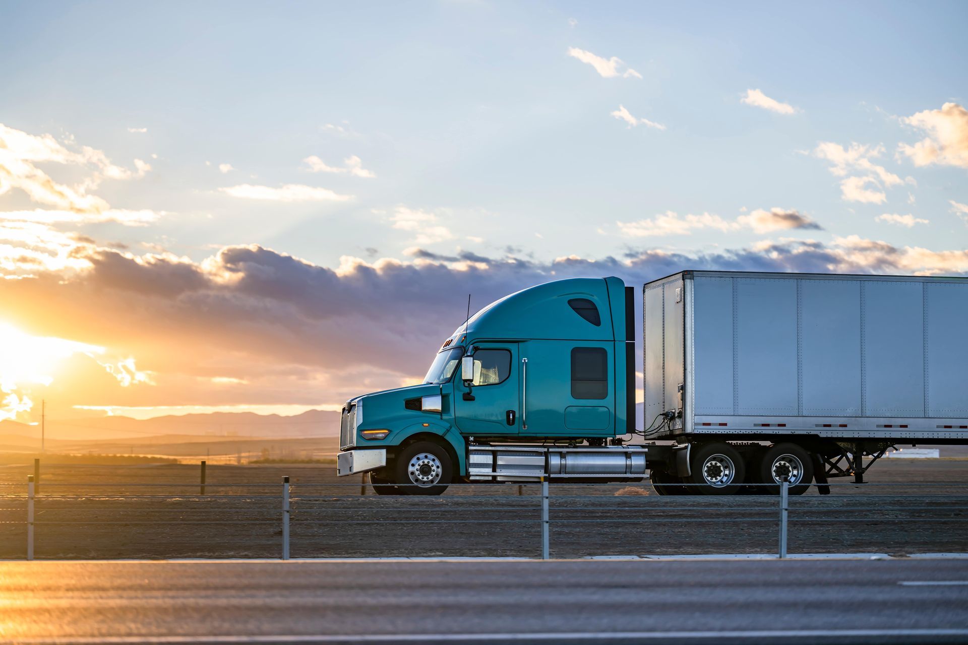 commercial fleet truck driving next to sunset