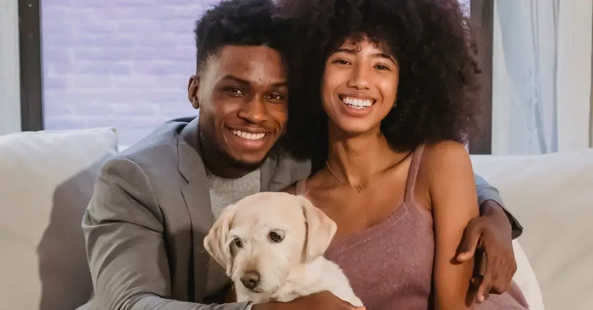 Smiling couple on a couch holding a cream-colored puppy in a bright living room