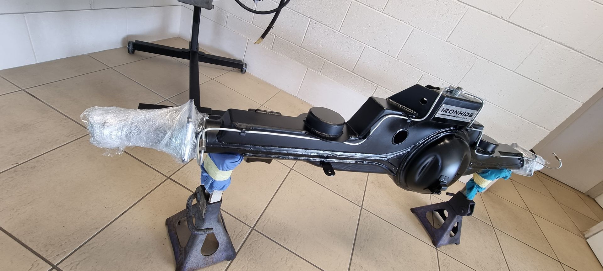 A Black Automotive Axle Assembly Rests on Two Jack Stands — Ironhide Customs In Garbutt, QLD