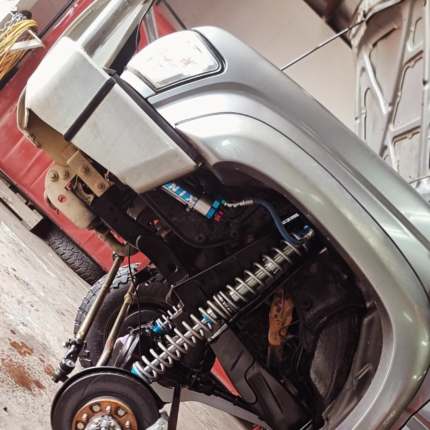 Silver Car With Exposed Front Suspension on a Lift in a Garage — Ironhide Customs In Garbutt, QLD