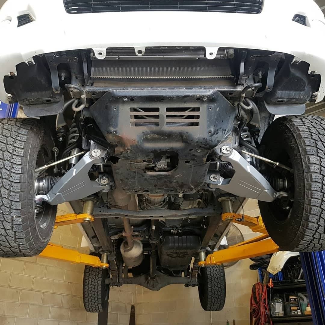 Underside of a white vehicle on a lift — Ironhide Customs In Garbutt, QLD