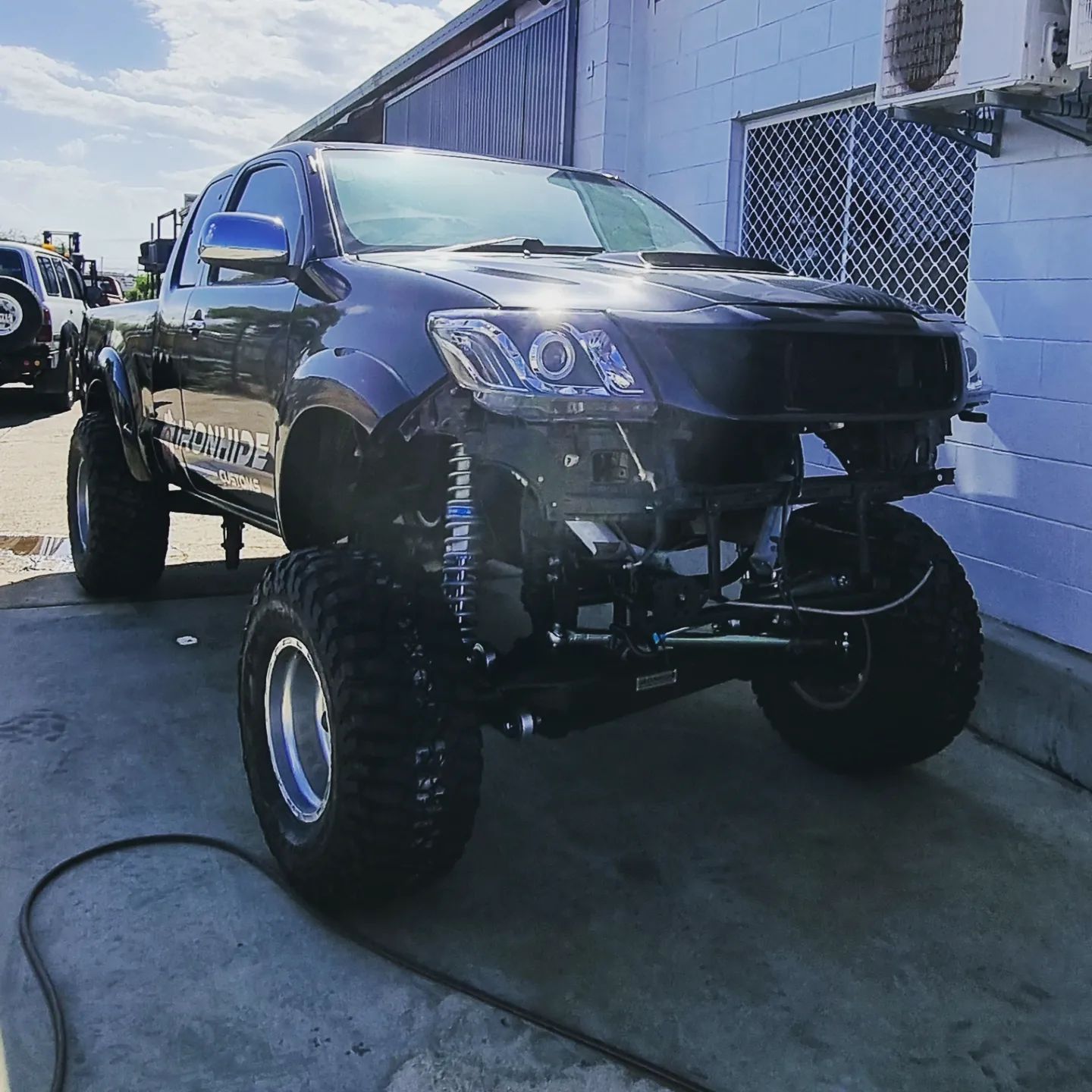 A Dark-Colored, Modified Pickup Truck with Large Off-Road Tires — Ironhide Customs In Garbutt, QLD