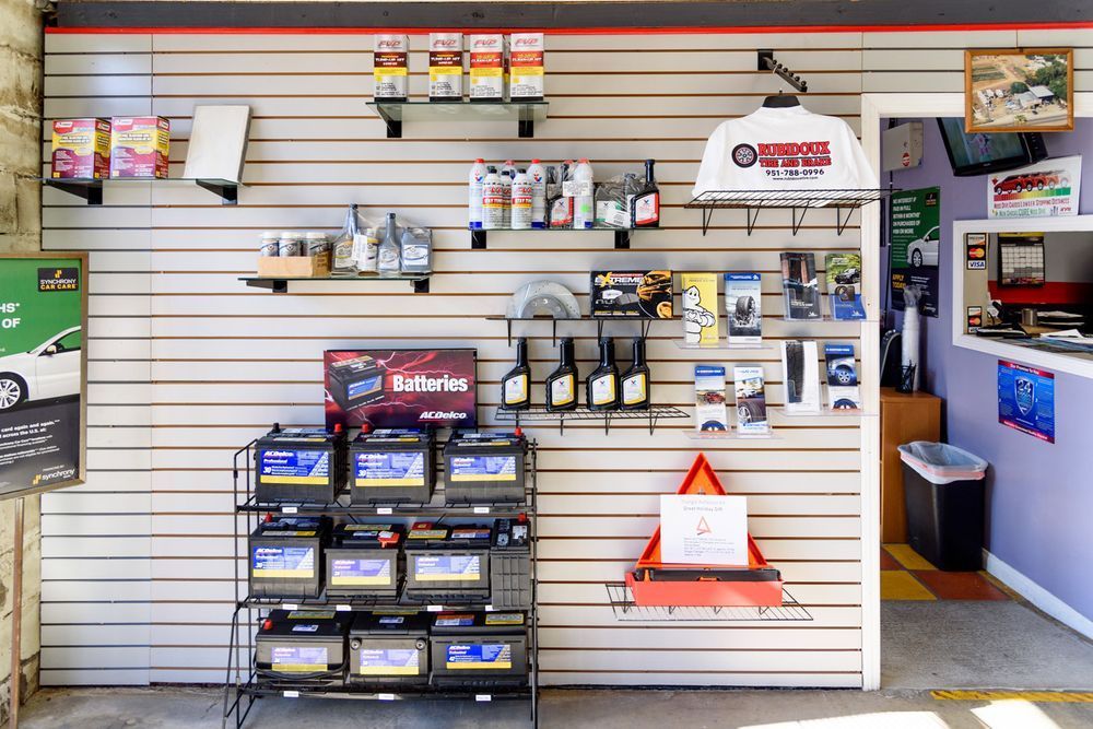 Store wall display with automotive products, shelves of parts, and a service counter on the right.