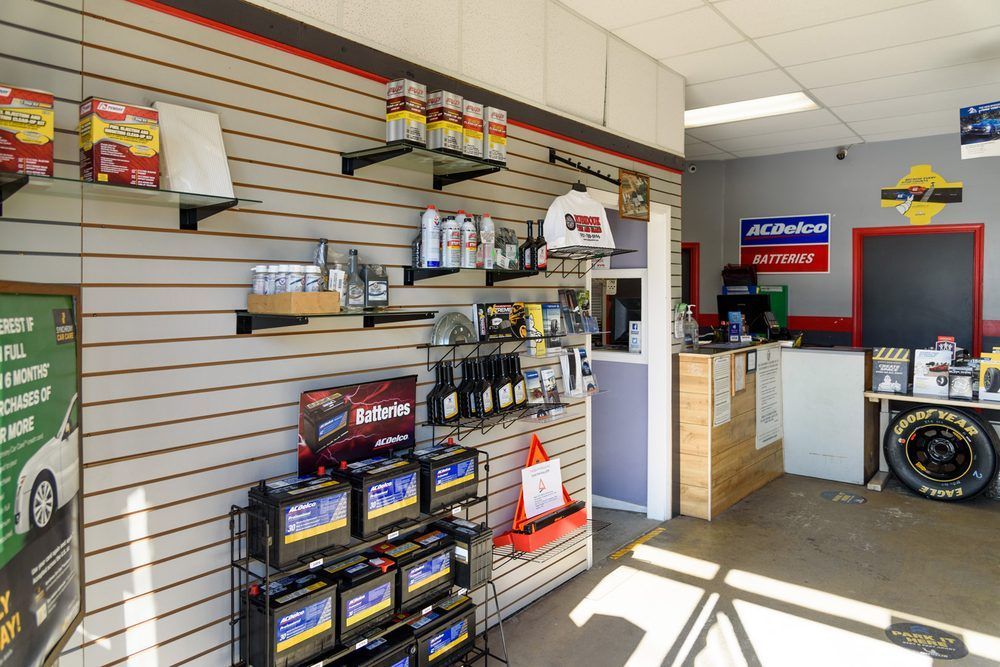 Auto shop interior with tires, car batteries, and wall-mounted parts displays