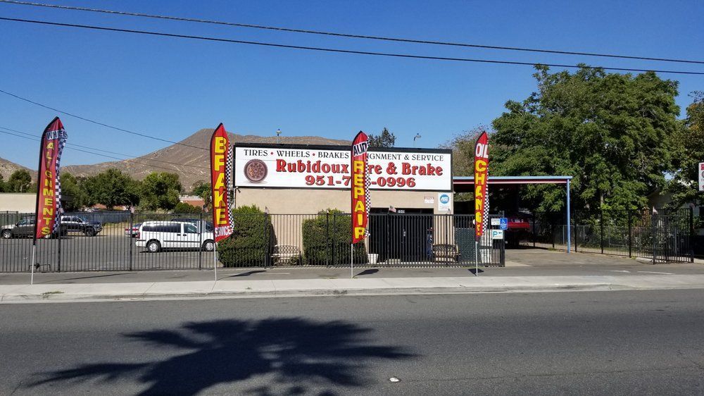 Street-side restaurant storefront with red-and-yellow signs and a parked white car in front
