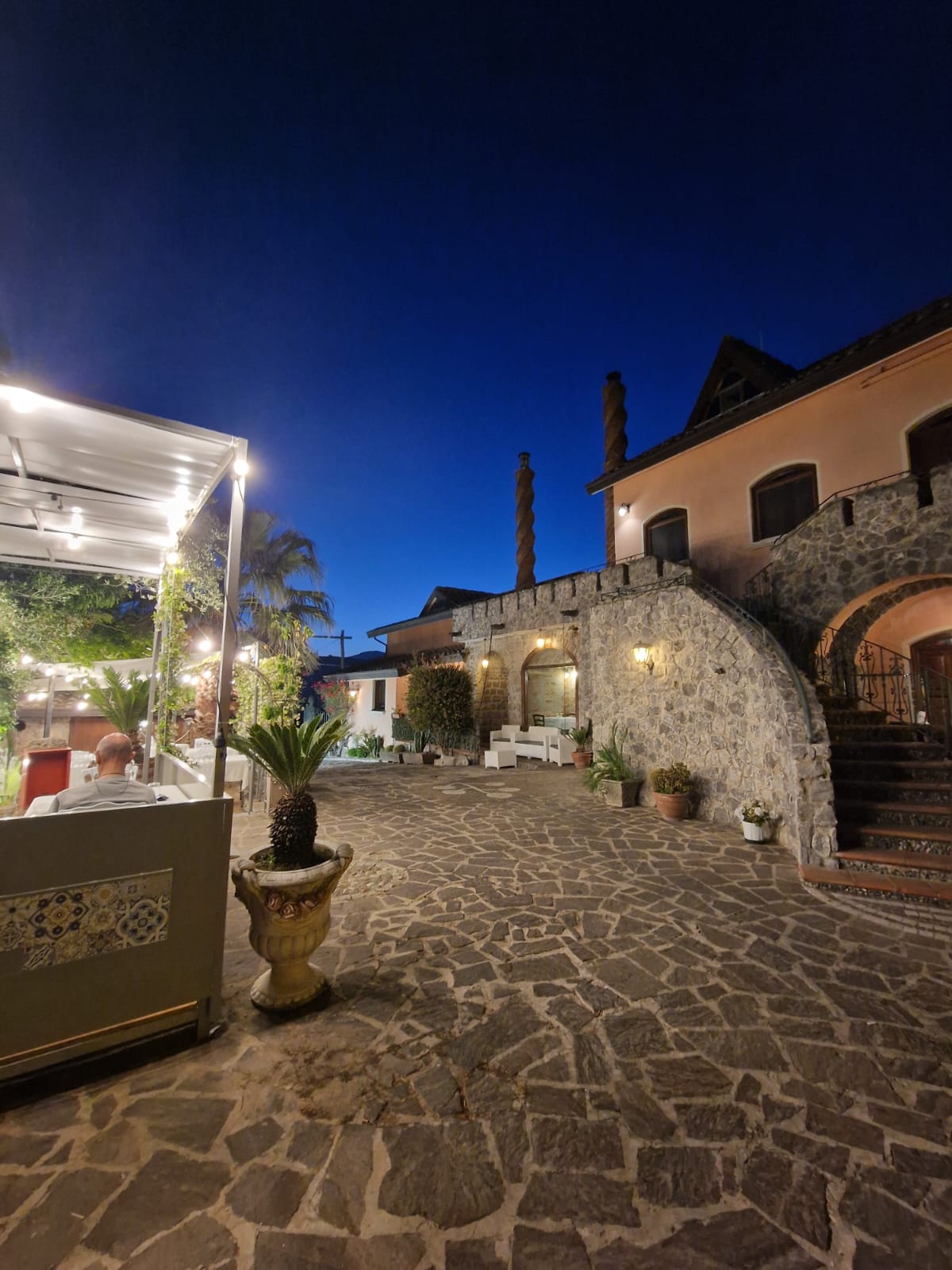 Un cortile in pietra con un edificio sullo sfondo di notte.