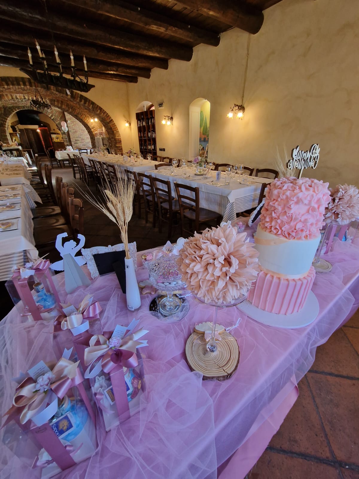 tavolo con una tovaglia rosa e una torta sopra