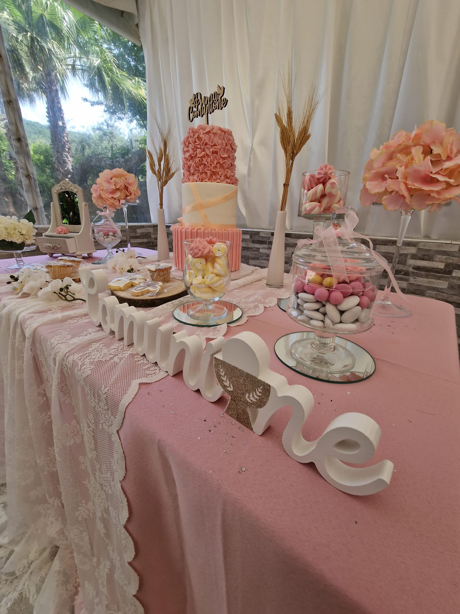 Un tavolo con una tovaglia rosa e una torta sopra.