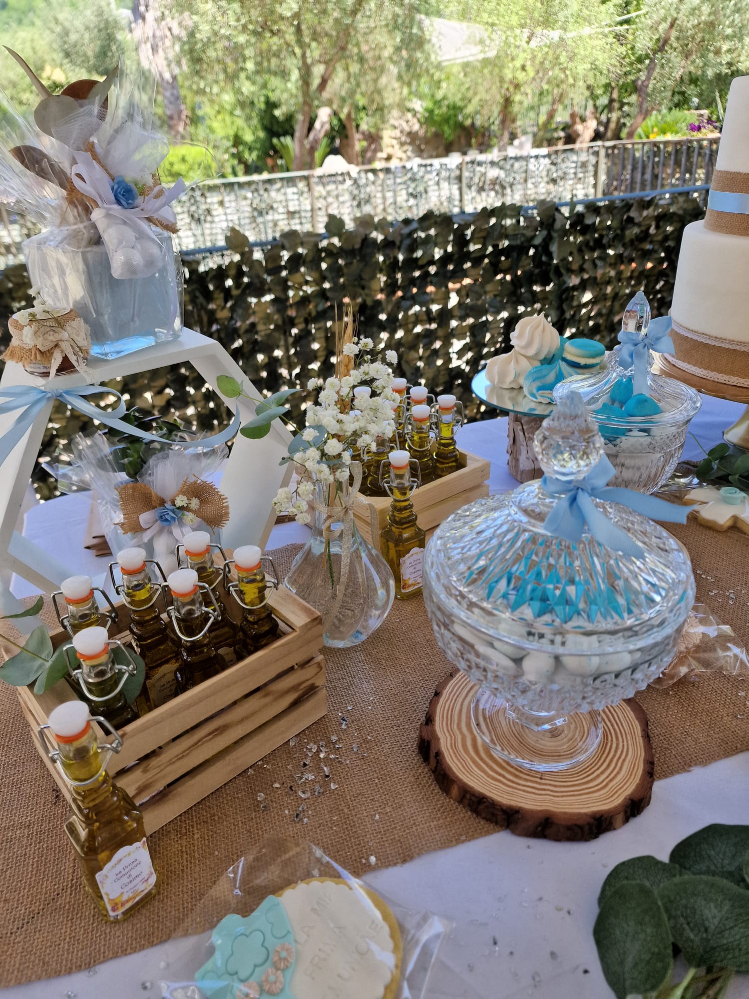 tavolo ornato da bottiglie di olio d'oliva, biscotti e una torta