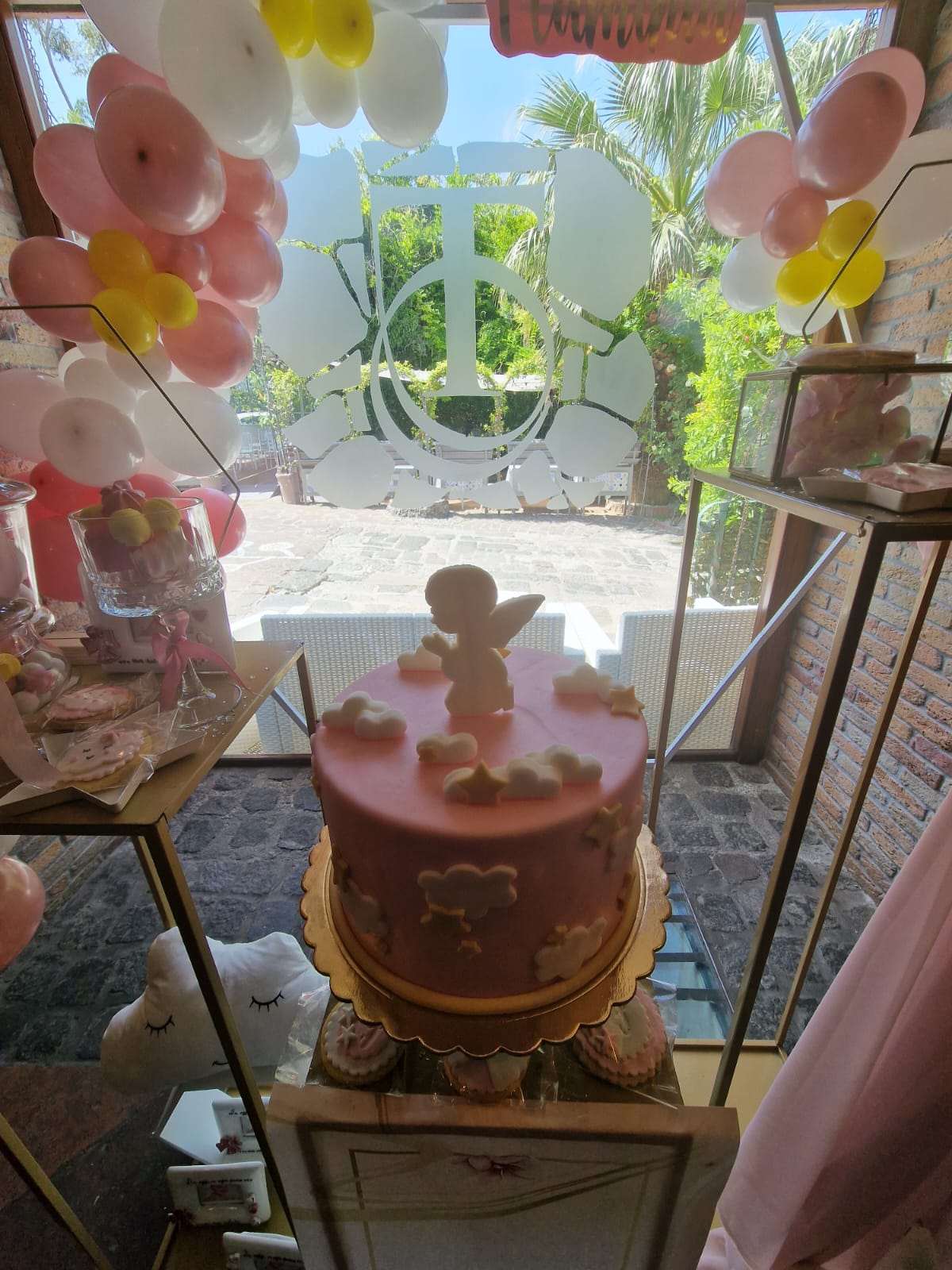 torta rosa a più piani allestita per un battesimo
