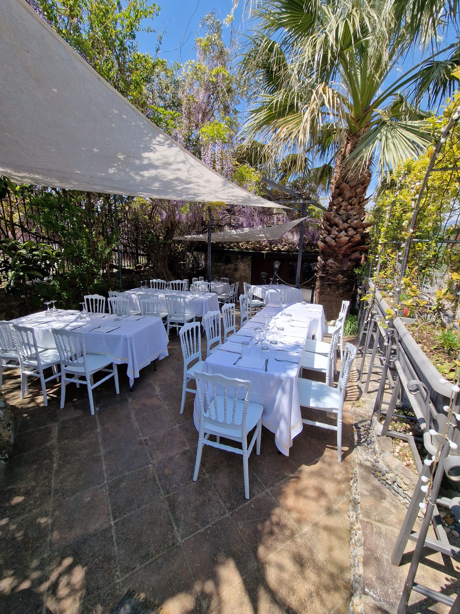 patio attrezzato con tavoli e sedie sotto gli ombrelloni