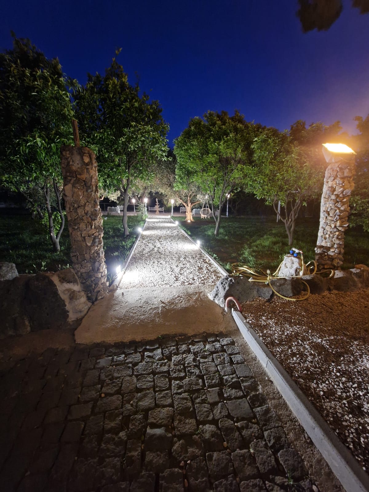 sentiero acciottolato illuminato di notte nel giardino di Tenuta Olivia