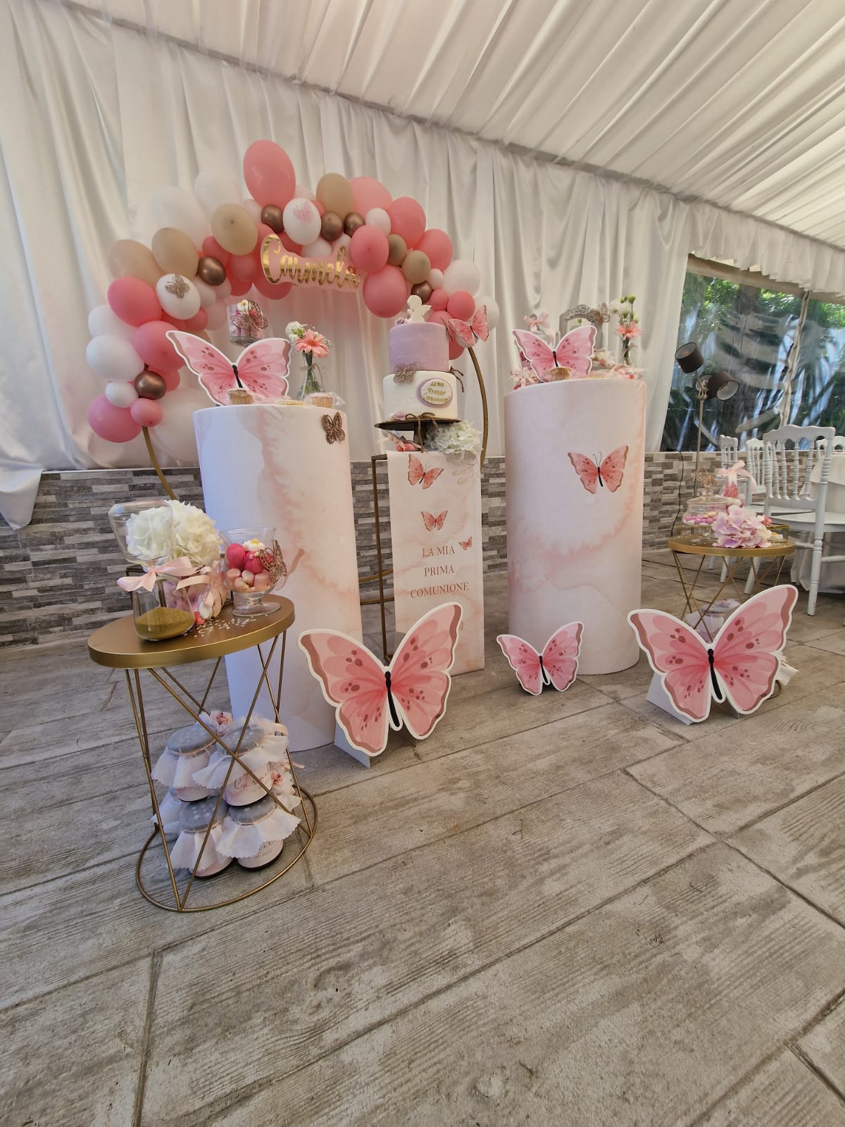 stanza decorata con farfalle rosa e palloncini per una prima comunione