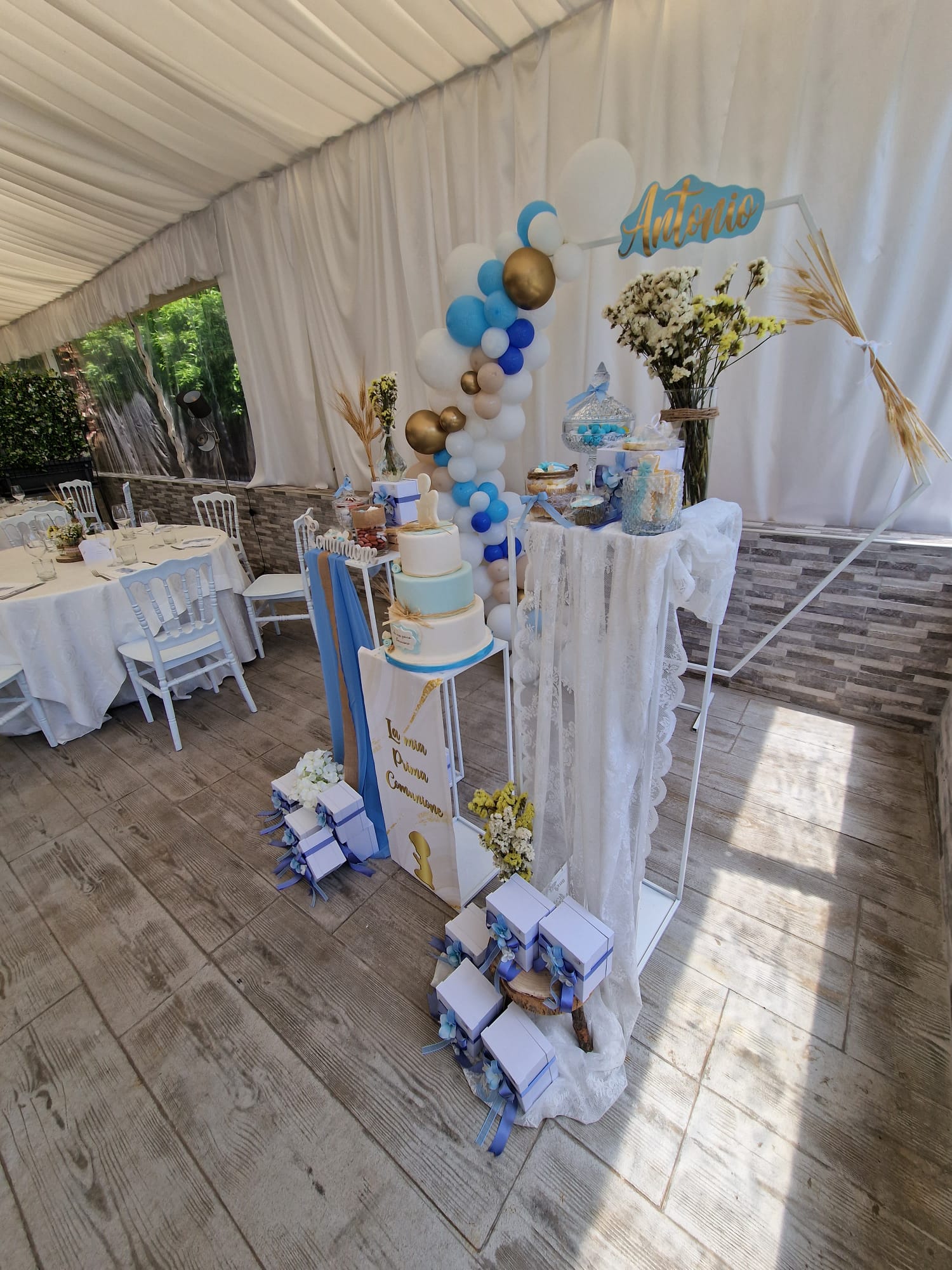 tavolo con una torta e dei palloncini per un pranzo di comunione