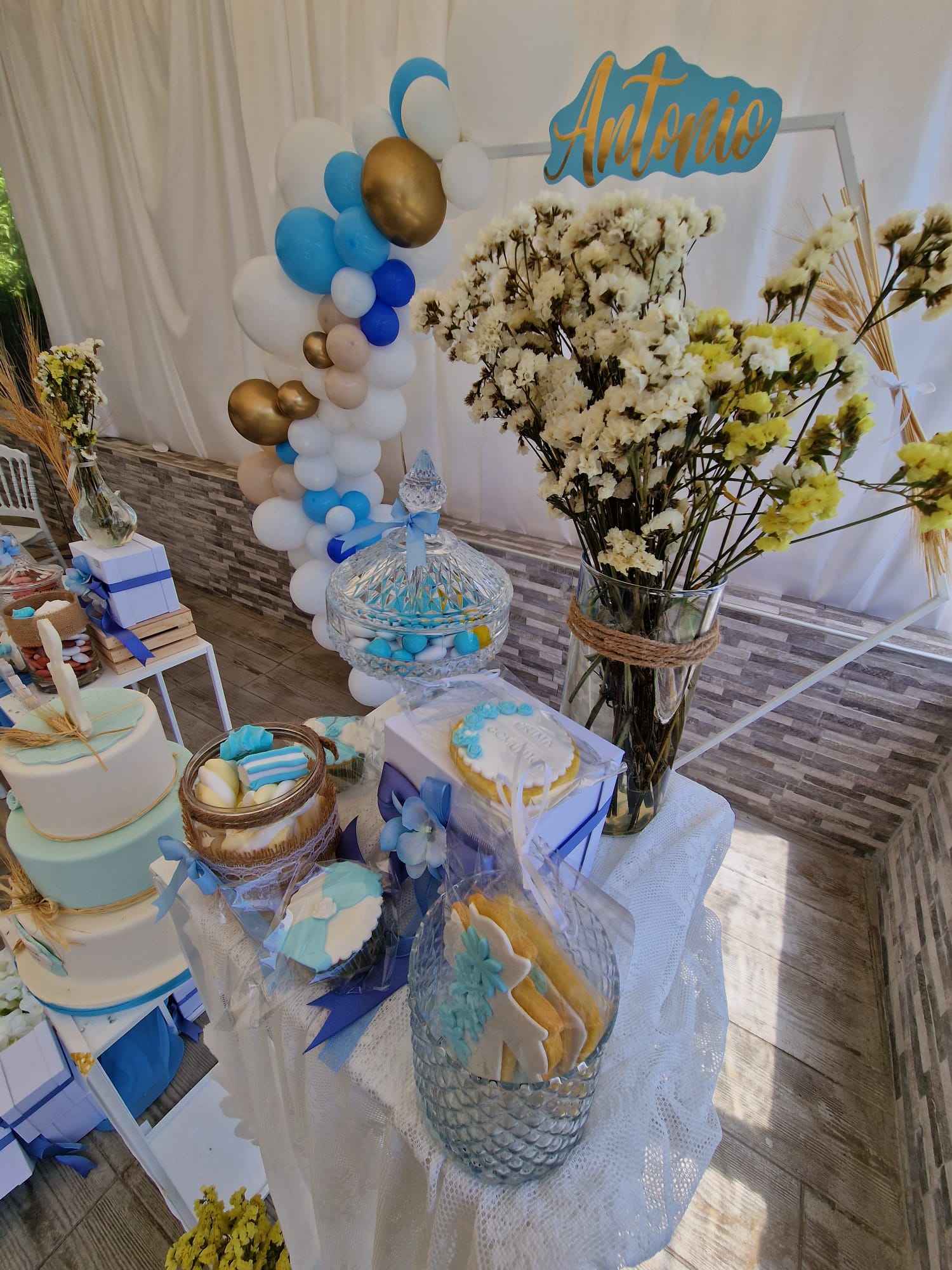 tavolo con palloncini, biscotti, fiori e una torta sopra