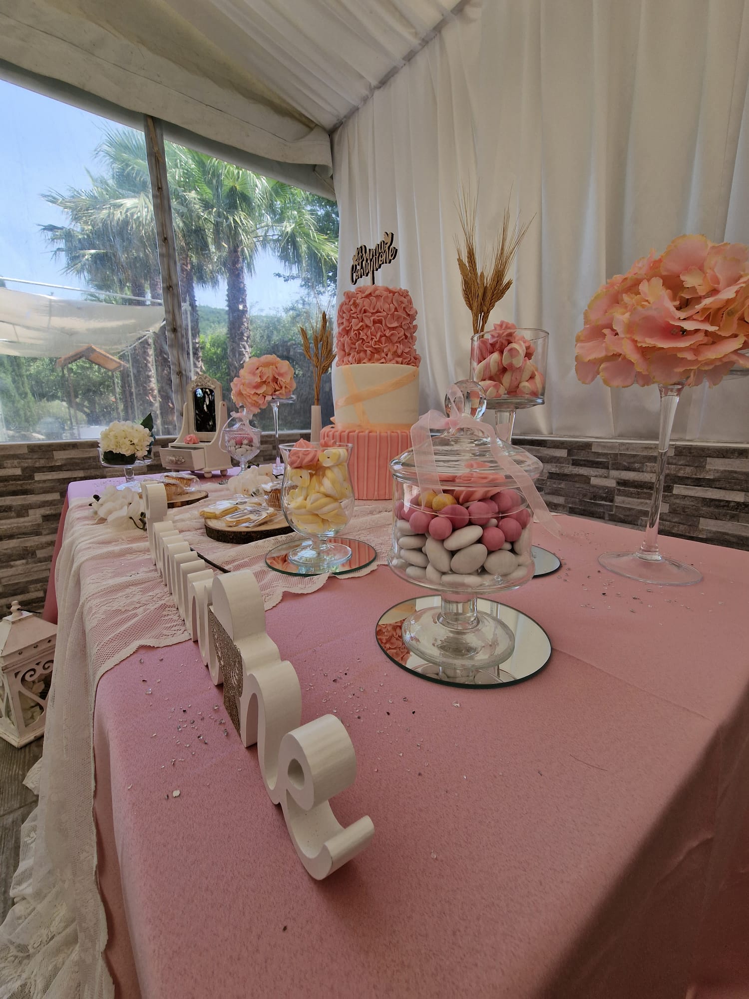 Un tavolo con una tovaglia rosa e una torta sopra.