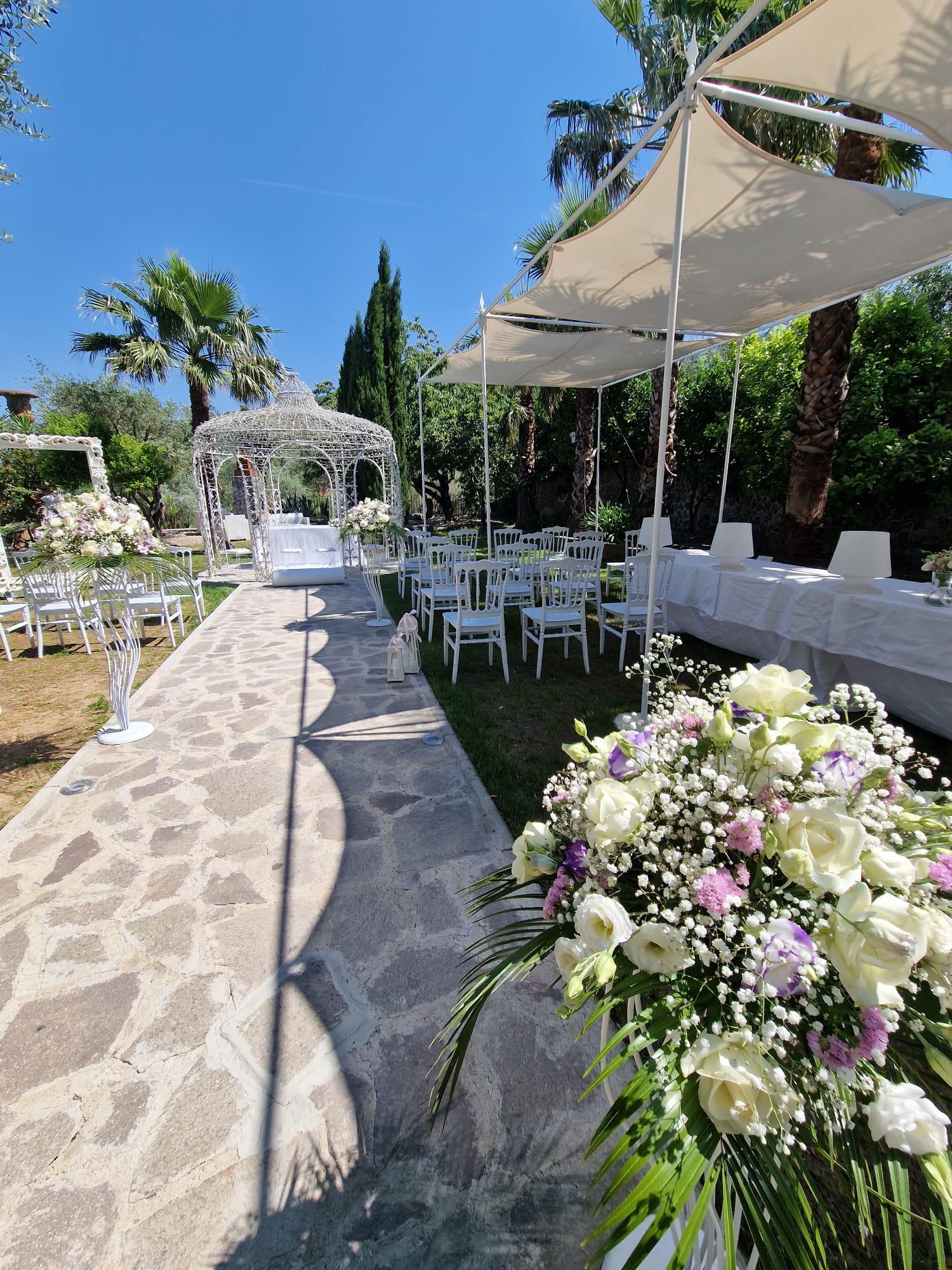 cerimonia nuziale in un giardino con fiori e tendoni