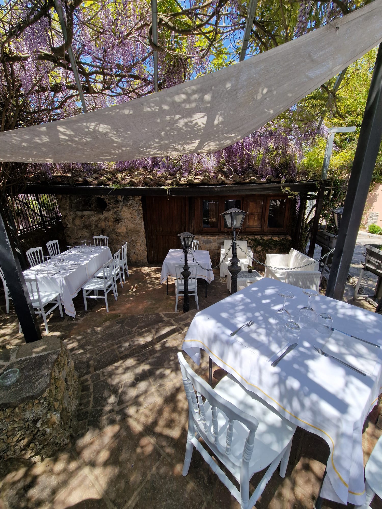 Un patio con tavoli e sedie sotto una tettoia.