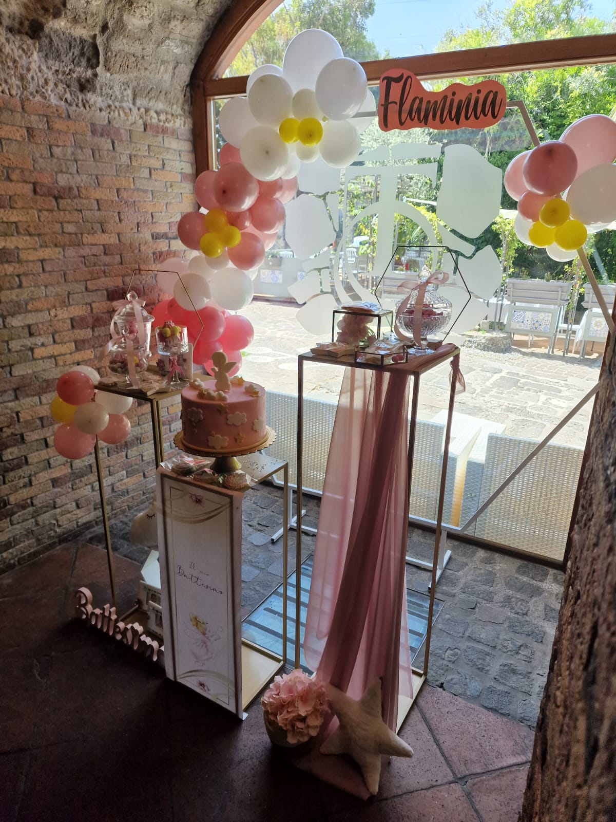stanza decorata con palloncini rosa e gialli e una torta