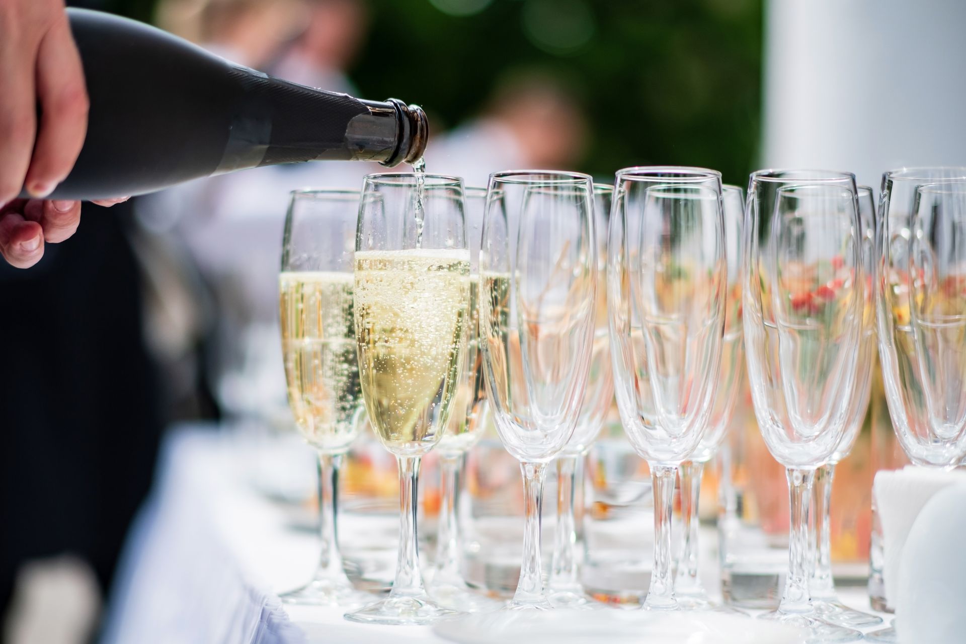Waiter pouring champagne into glass.