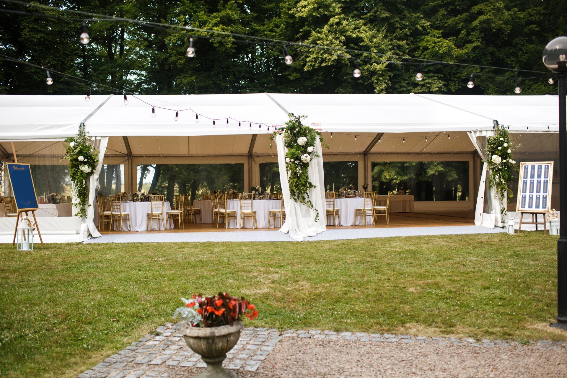 Long white tent for wedding party in the woods.