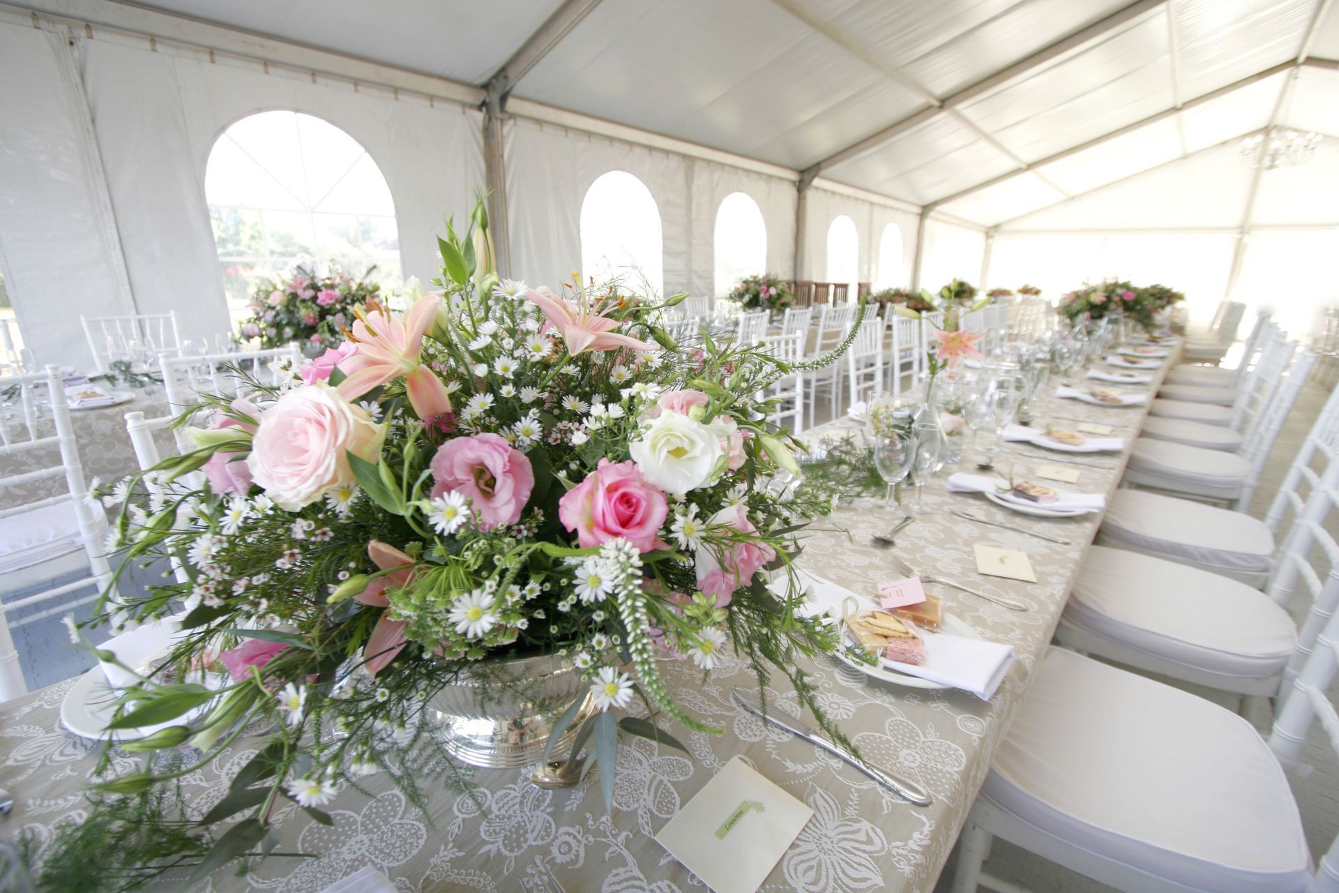 A table setup for a wedding reception in a big tent