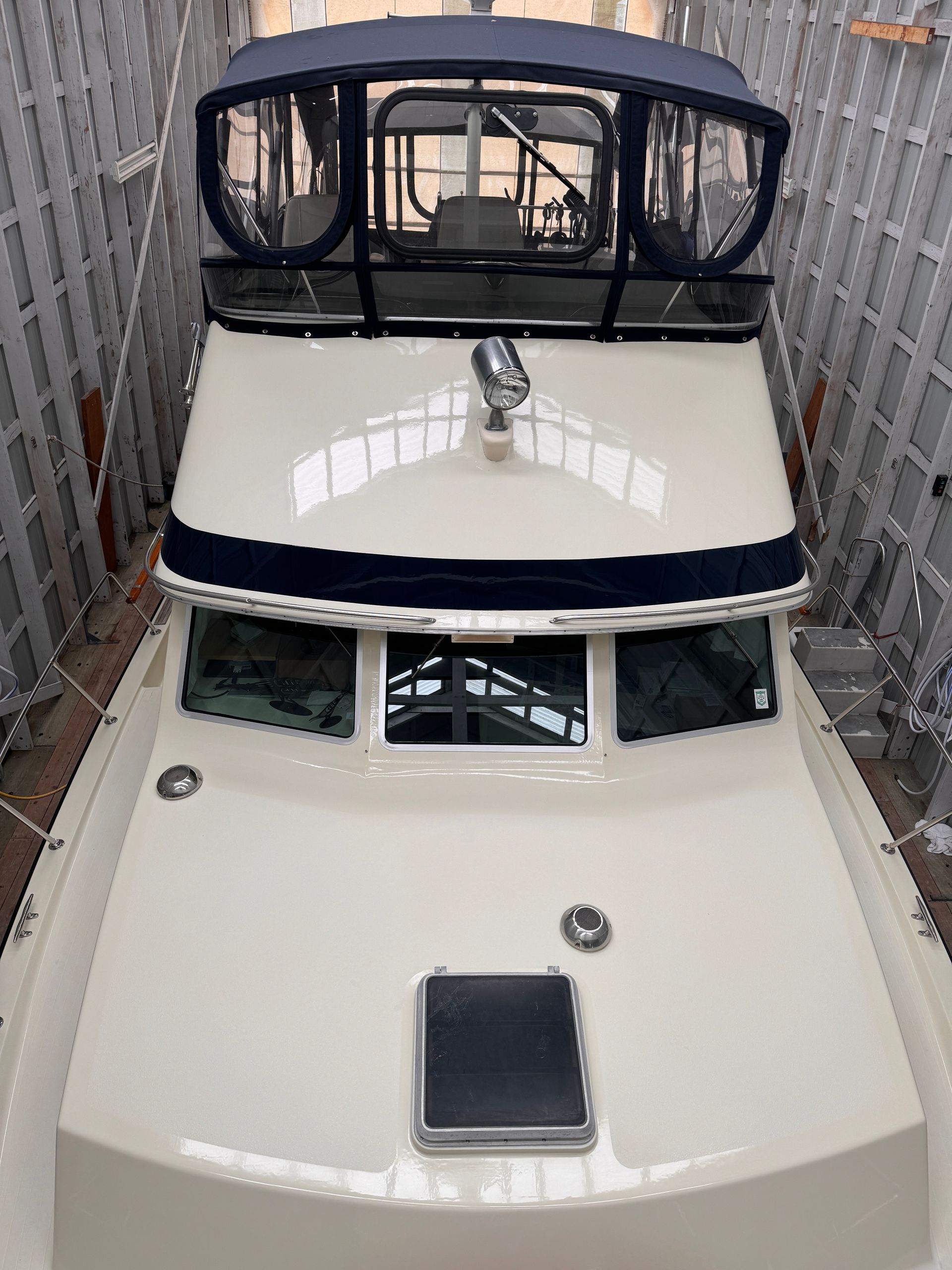 The front of a boat is sitting in a warehouse.