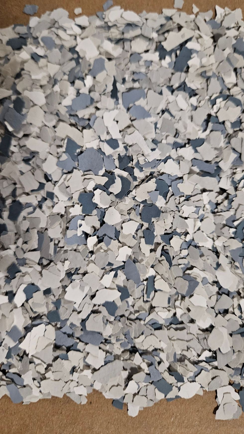Gray, white, and blue epoxy floor flakes, scattered.