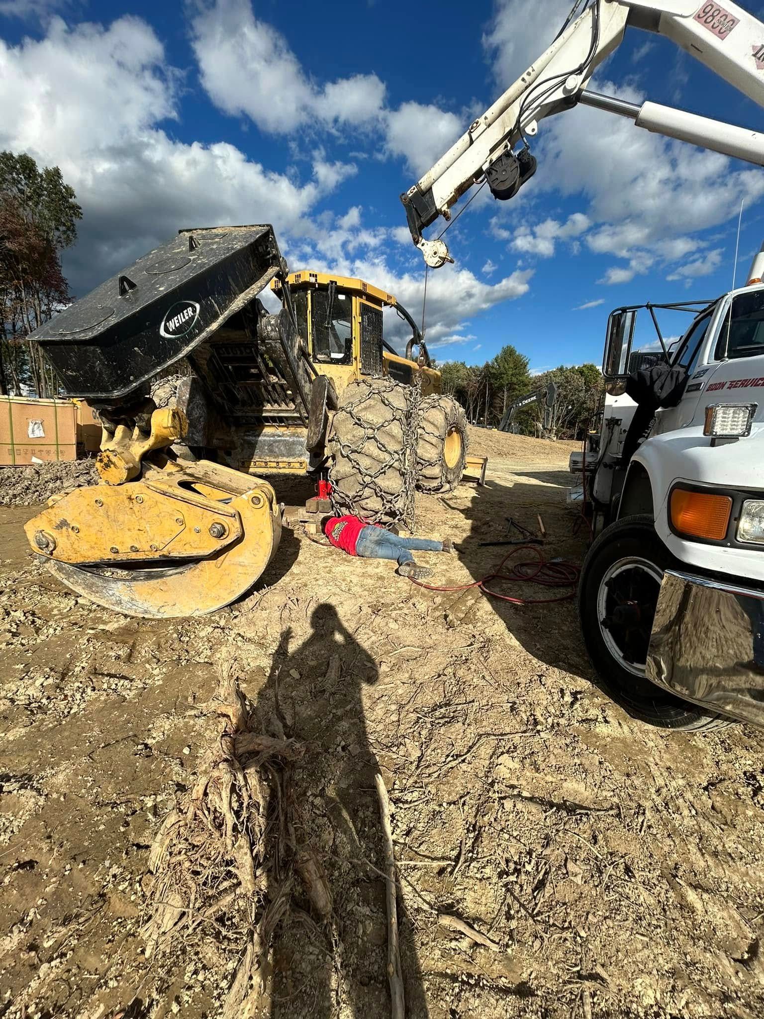 A bulldozer and a truck are parked in a dirt field.