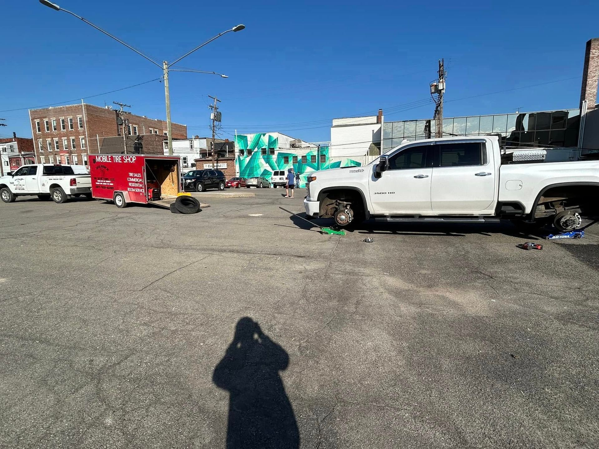 A white truck is parked in a parking lot in front of a building.