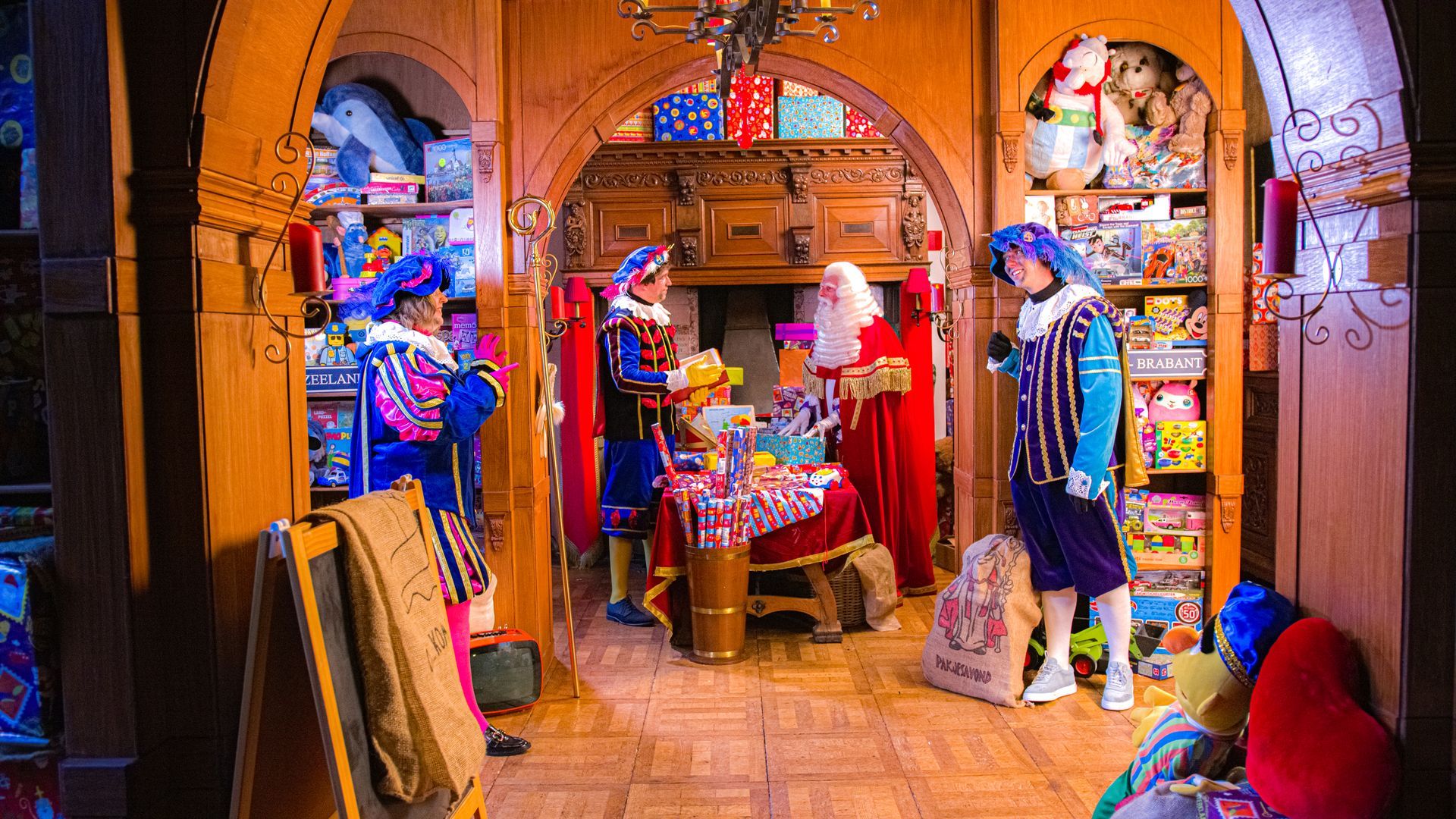 Sinterklaas aan het werk in de pakjeskamer met 3 roetveeg pieten