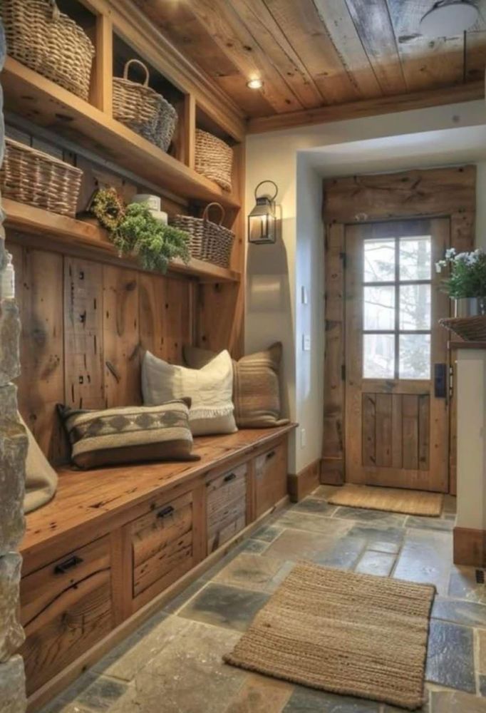 Rustic mudroom with wood bench, woven baskets, greenery, and a glass-paneled door