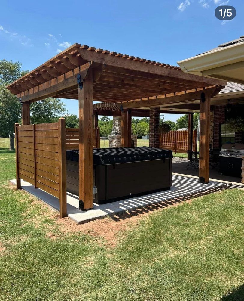 Wooden outdoor pergola with a hot tub, privacy screens, and a grassy backyard setting
