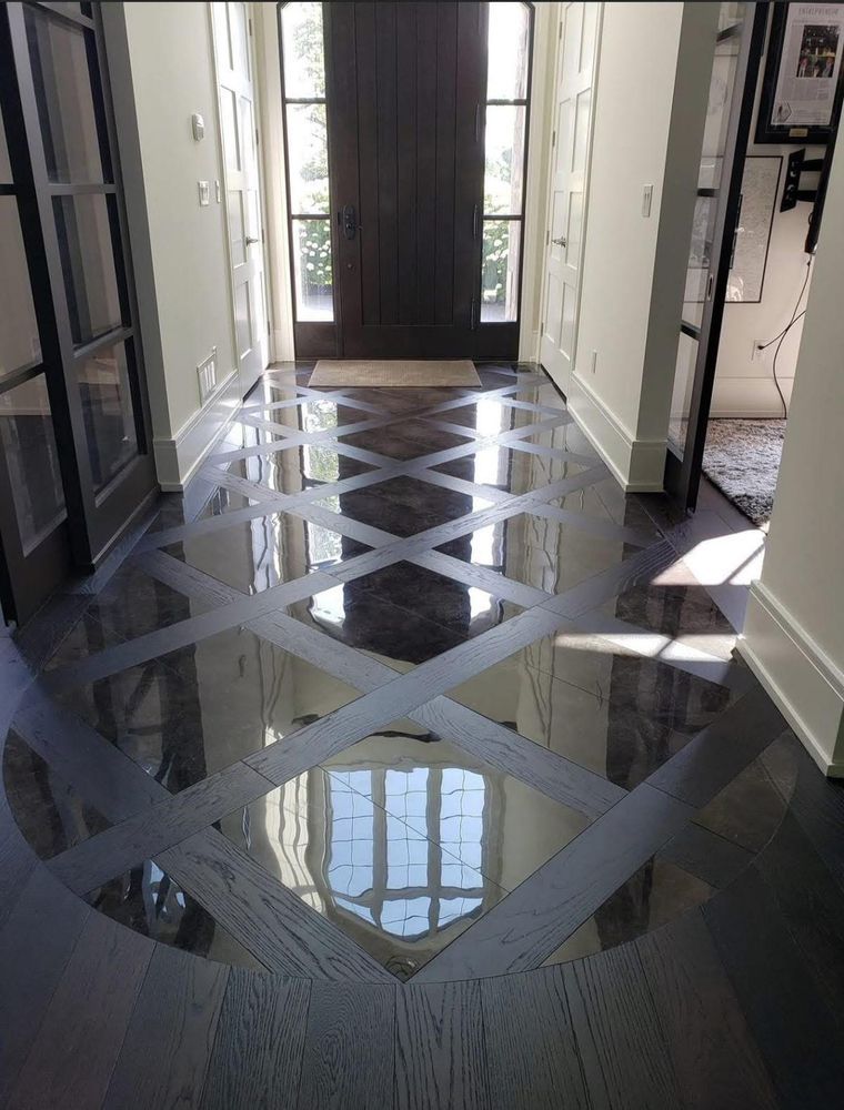 Hallway with glossy dark geometric floor pattern and a front door at the end