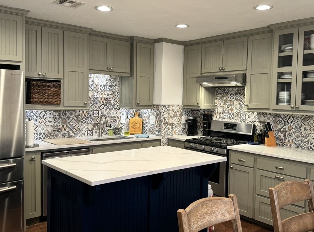 Modern kitchen with gray cabinets, mosaic backsplash, and a white island countertop