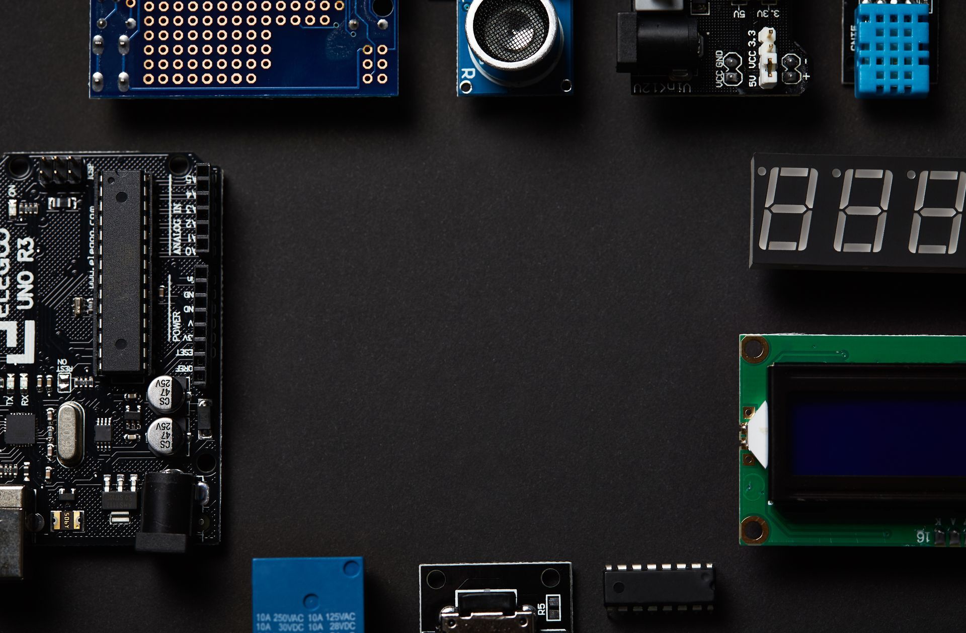 A bunch of electronic components are laid out on a black surface