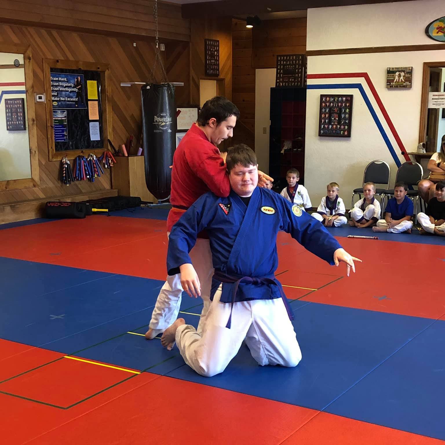 Two men are practicing martial arts in a gym