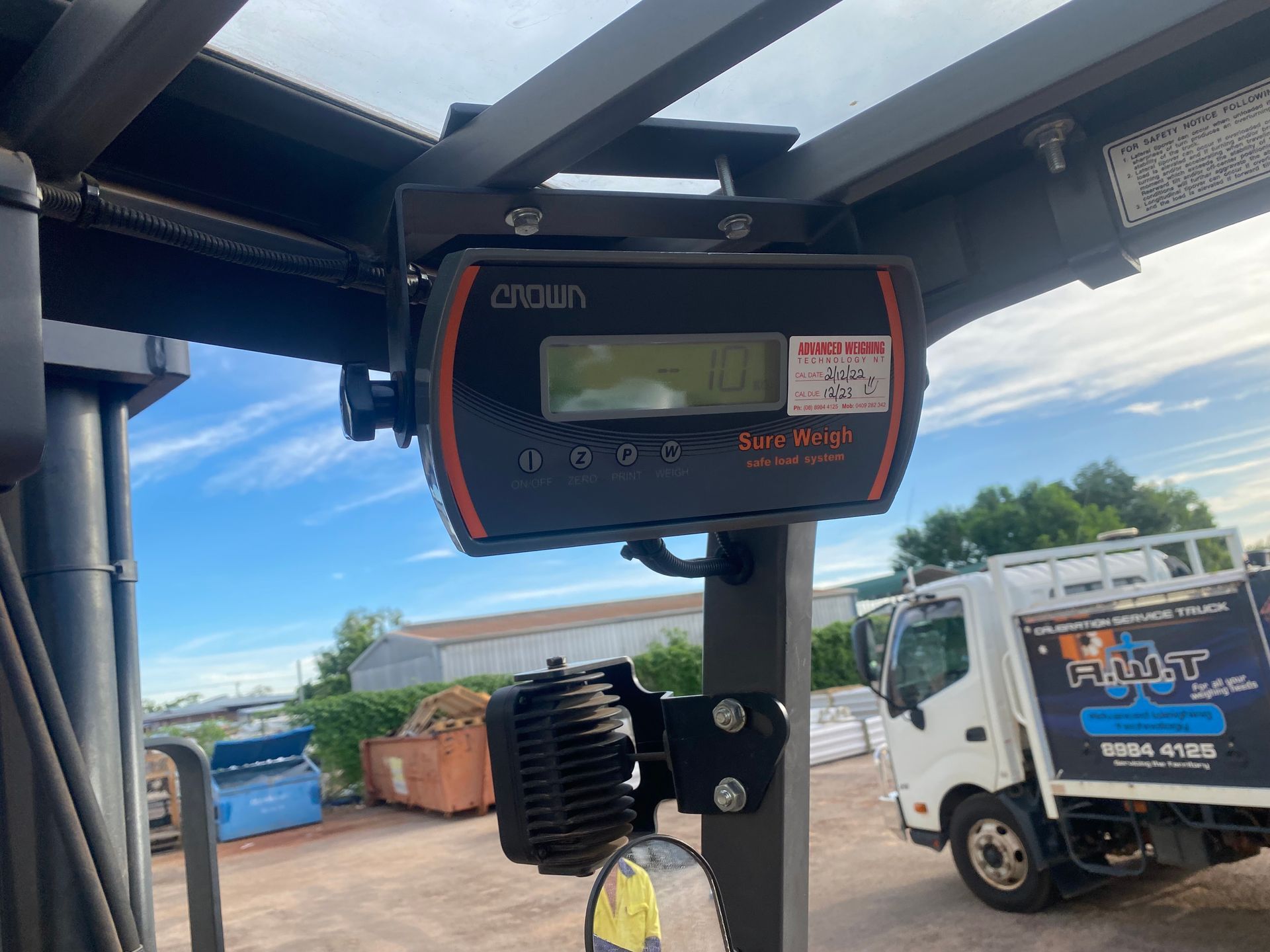 Crown forklift weight scale mounted to the overhead guard, with a truck visible in the background outdoors — Advanced Weighing Technology NT Pty Ltd In Winnellie, NT