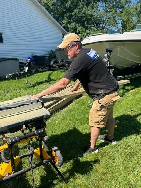A man is using a table saw to cut a piece of wood.