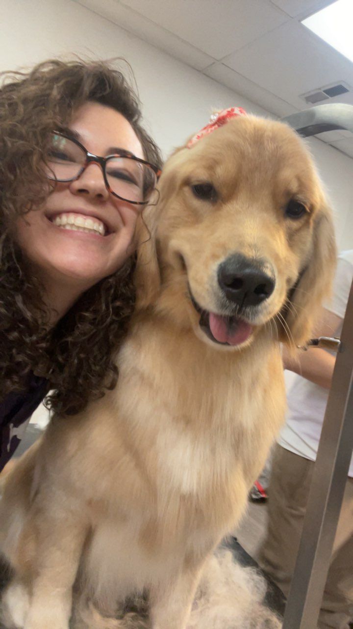 A woman is posing for a picture with a puppy.