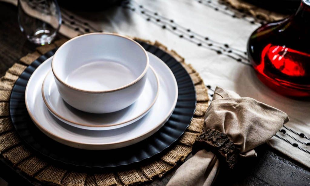 A table setting with plates , bowls , and a napkin.