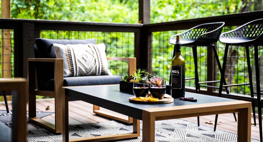 There is a table with a bottle of wine on it on the deck in preparation of photo staging for photo staging.