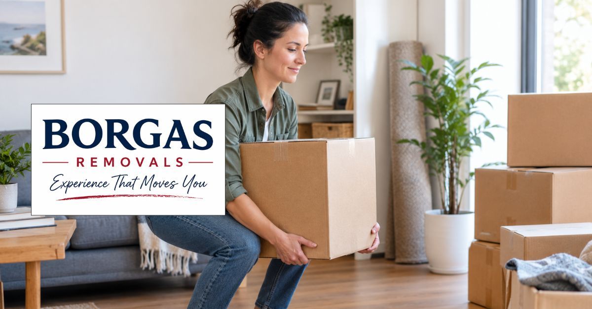 Homeowner lifting a moving box with bent knees while preparing household belongings for removal.